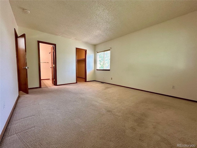 13191 Umatilla St, Denver, CO 80234 - unfurnished bedroom featuring a textured ceiling, light colored carpet, and a walk in closet