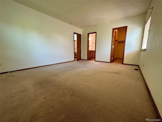 13191 Umatilla St, Denver, CO 80234 - unfurnished bedroom featuring light colored carpet, a spacious closet, a textured ceiling, and ensuite bathroom