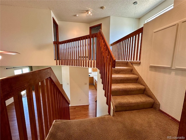 13191 Umatilla St, Denver, CO 80234 - staircase featuring a textured ceiling and carpet