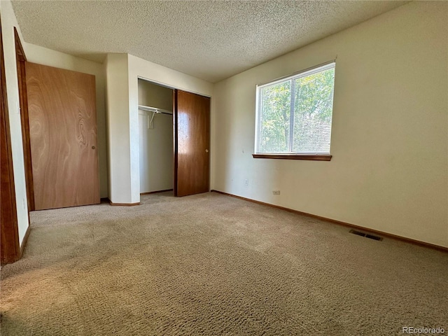 13191 Umatilla St, Denver, CO 80234 - unfurnished bedroom with light colored carpet, a textured ceiling, and a closet