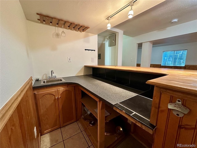 13191 Umatilla St, Denver, CO 80234 - indoor wet bar featuring light tile patterned floors, a textured ceiling, and track lighting