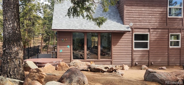 view of property exterior featuring fence and roof with shingles