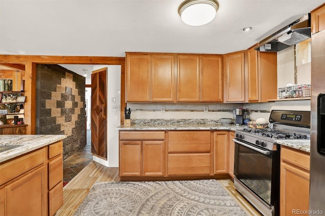 1575 York Gulch Rd, Idaho Springs, CO 80452 - kitchen with stainless steel range with gas stovetop, light wood finished floors, and light stone counters