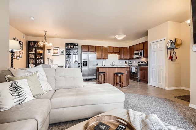 7292 S Blackhawk St Unit 2-204, Englewood, CO 80112 - living room featuring a chandelier, light tile patterned floors, and baseboards