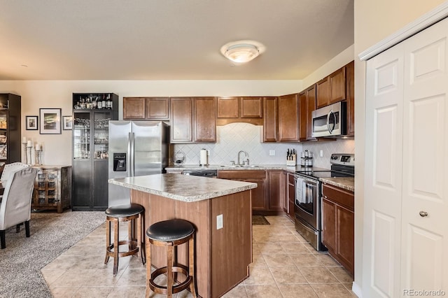 7292 S Blackhawk St Unit 2-204, Englewood, CO 80112 - kitchen with stainless steel appliances, a sink, a kitchen bar, a center island, and tasteful backsplash