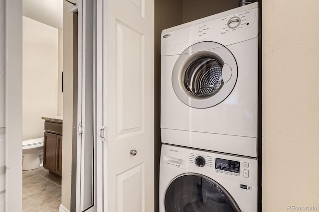 7292 S Blackhawk St Unit 2-204, Englewood, CO 80112 - clothes washing area featuring stacked washer and clothes dryer and light tile patterned floors
