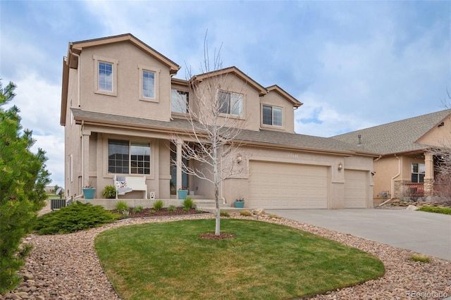 traditional home featuring stucco siding, driveway, a front yard, and an attached garage