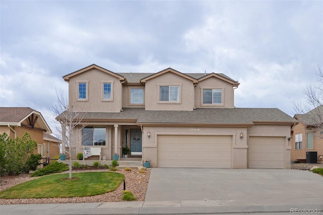 traditional home with central AC unit, stucco siding, driveway, a garage, and a front yard