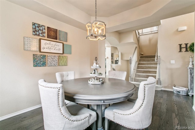 dining area with arched walkways, baseboards, a chandelier, and stairway