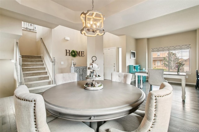 dining room featuring a chandelier, stairway, and wood finished floors