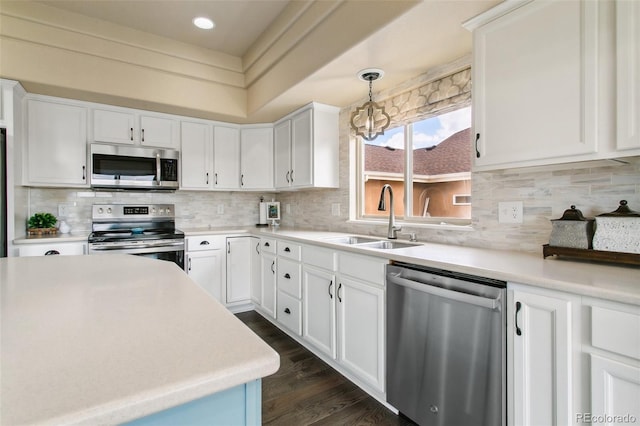 kitchen featuring appliances with stainless steel finishes, a sink, decorative backsplash, light countertops, and recessed lighting