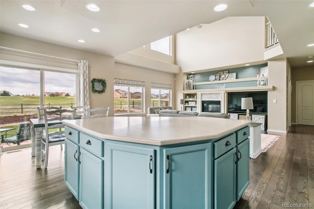 kitchen with dark wood finished floors, a center island, light countertops, open floor plan, and recessed lighting