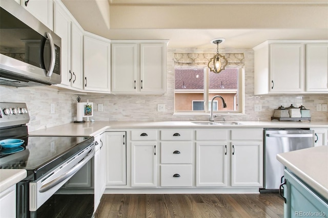 kitchen featuring appliances with stainless steel finishes, a sink, white cabinets, backsplash, and light countertops