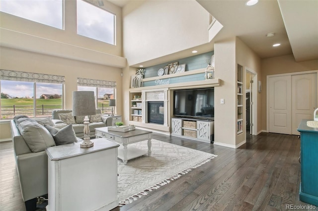 living room with dark wood-type flooring, baseboards, and recessed lighting