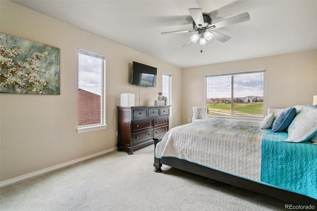 bedroom featuring light carpet, baseboards, and ceiling fan