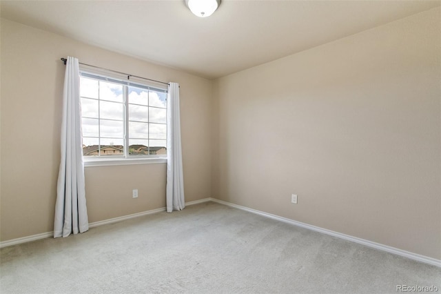 empty room featuring carpet and baseboards