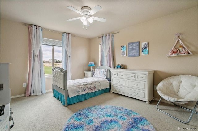 bedroom with light carpet, baseboards, and a ceiling fan