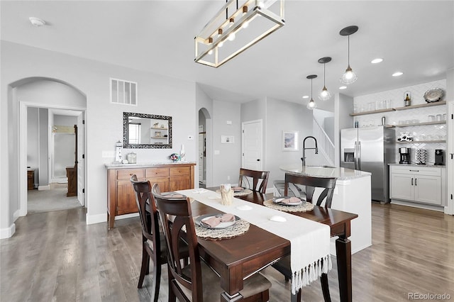 484 N Jamestown Way, Aurora, CO 80018 - dining area with arched walkways, bar, wood finished floors, recessed lighting, and baseboards