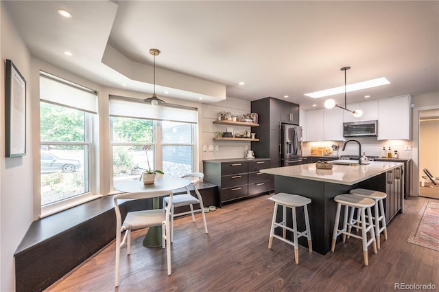 995 Chase St, Lakewood, CO 80214 - kitchen with appliances with stainless steel finishes, dark wood-type flooring, modern cabinets, a breakfast bar, and open shelves