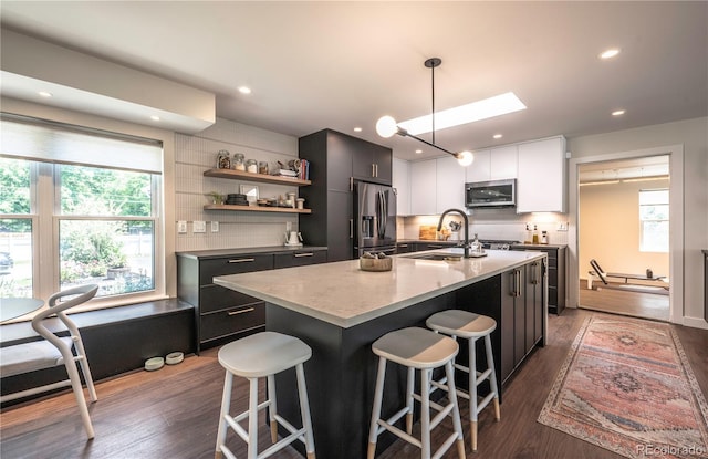 995 Chase St, Lakewood, CO 80214 - kitchen with stainless steel appliances, tasteful backsplash, a kitchen breakfast bar, and recessed lighting