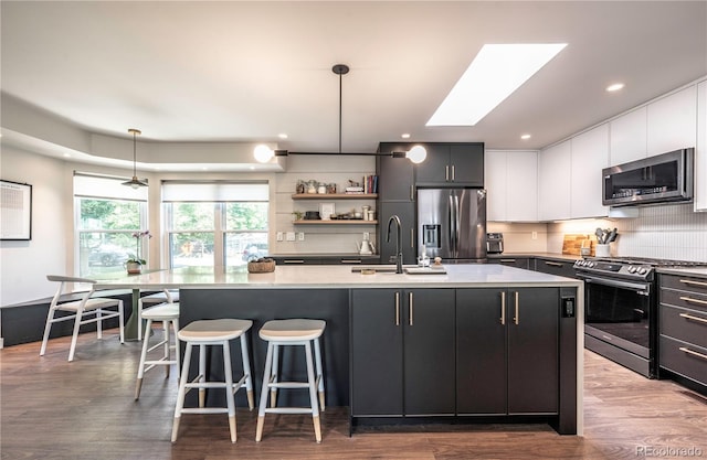 995 Chase St, Lakewood, CO 80214 - kitchen with stainless steel appliances, tasteful backsplash, hanging light fixtures, light countertops, and a skylight