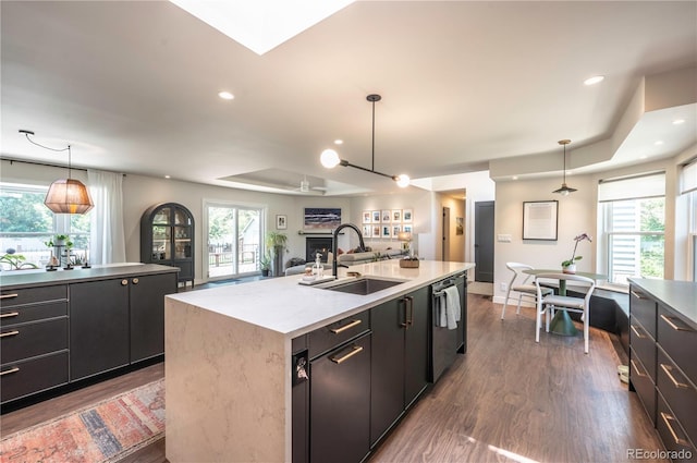995 Chase St, Lakewood, CO 80214 - kitchen featuring dishwashing machine, a center island with sink, dark wood finished floors, a fireplace, and recessed lighting