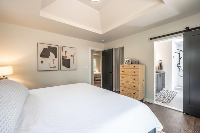 995 Chase St, Lakewood, CO 80214 - bedroom with a raised ceiling, dark wood-style flooring, a barn door, and ensuite bath