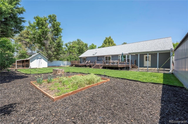 995 Chase St, Lakewood, CO 80214 - view of yard featuring a vegetable garden, a deck, and an outbuilding