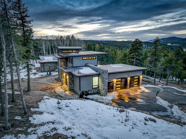 view of front of house featuring a mountain view and a view of trees