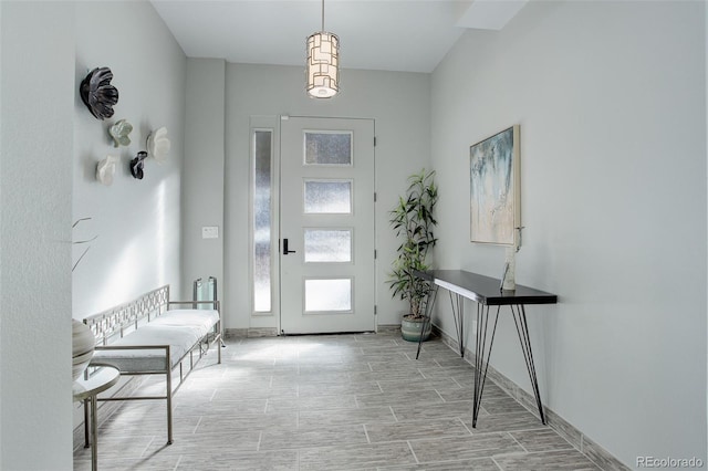 entrance foyer with baseboards and wood tiled floor