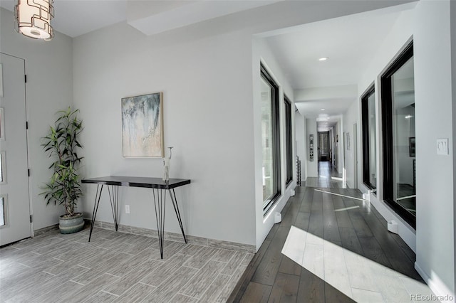 hallway featuring baseboards and dark wood-type flooring