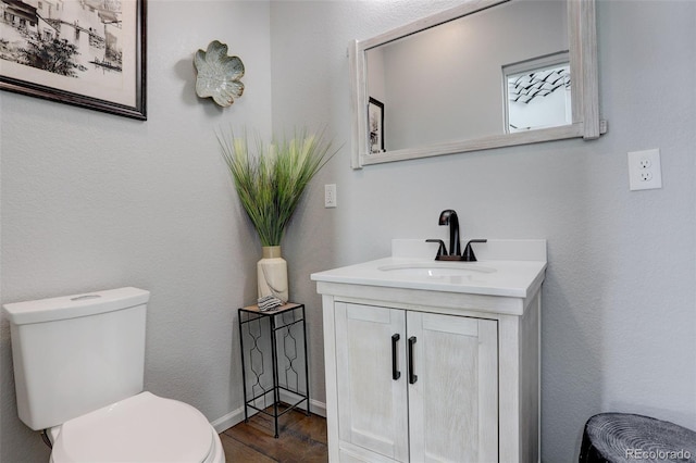 bathroom featuring vanity, toilet, and wood finished floors