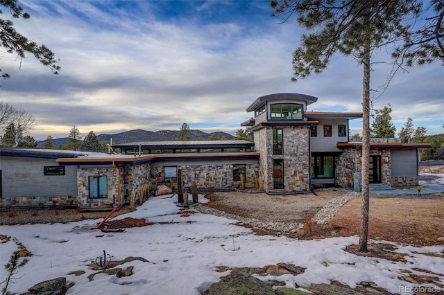 view of front facade featuring a garage, stone siding, and a mountain view