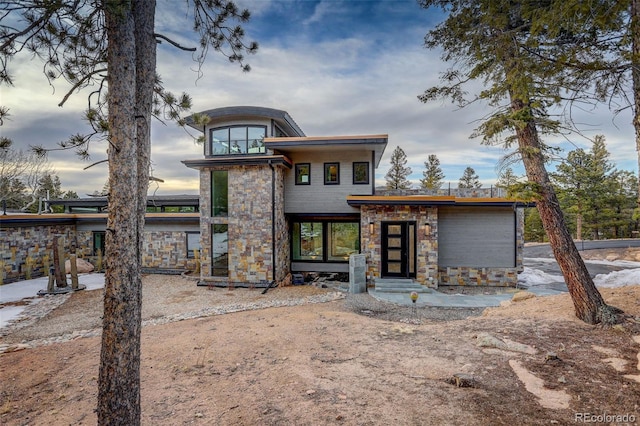 view of front of house with entry steps and stone siding