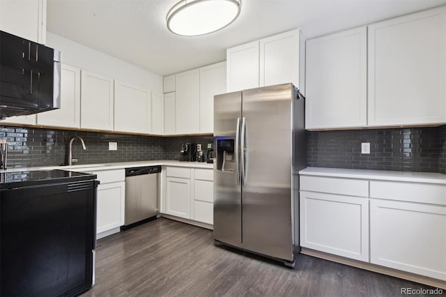 kitchen with dark hardwood / wood-style flooring, sink, tasteful backsplash, white cabinetry, and appliances with stainless steel finishes