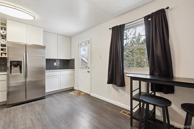 kitchen with white cabinetry, stainless steel refrigerator with ice dispenser, dark hardwood / wood-style flooring, and tasteful backsplash