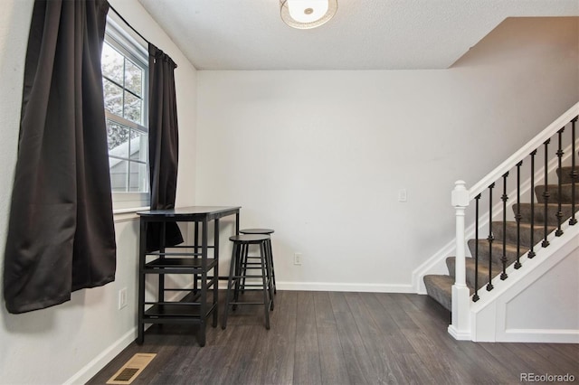 dining room featuring dark hardwood / wood-style flooring and a textured ceiling