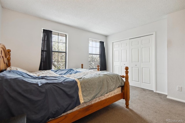 carpeted bedroom with a closet and a textured ceiling