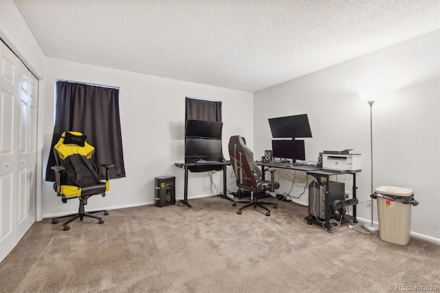 carpeted home office featuring a textured ceiling