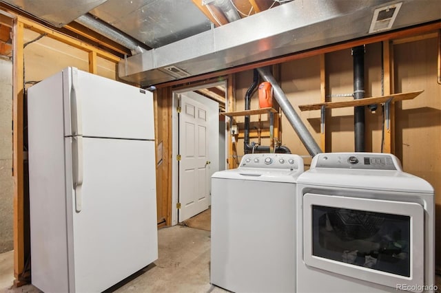 clothes washing area with separate washer and dryer