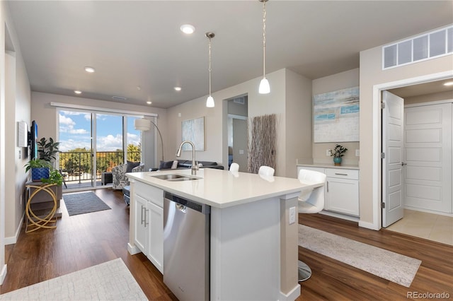 kitchen with a sink, stainless steel dishwasher, dark wood-style floors, white cabinets, and decorative light fixtures