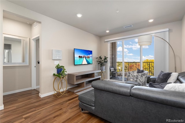 living room with wood finished floors, baseboards, and recessed lighting