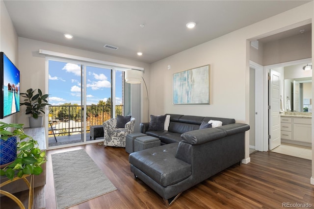 living area with healthy amount of natural light, wood finished floors, recessed lighting, and baseboards