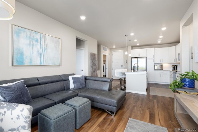 living room with dark wood-style flooring and recessed lighting