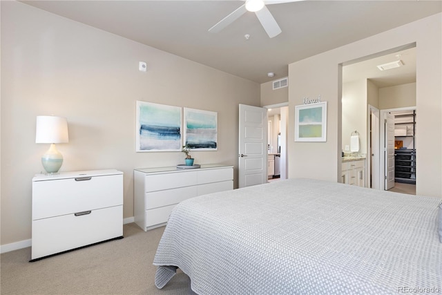 bedroom with baseboards, light colored carpet, a ceiling fan, and ensuite bath