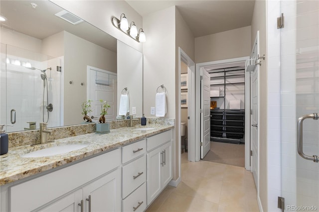 full bath with a stall shower, toilet, tile patterned flooring, and double vanity