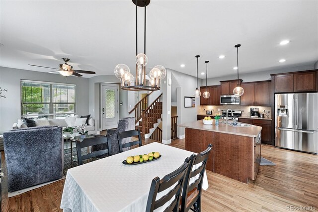 3644 Wabash St, Denver, CO 80238 - dining room featuring light wood-type flooring, stairs, a ceiling fan, recessed lighting, and a chandelier