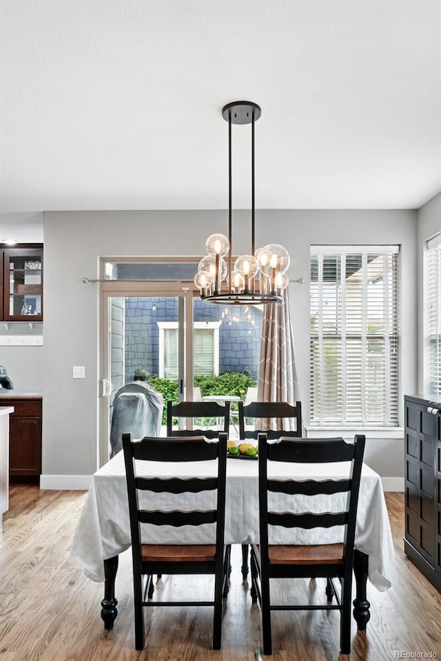 3644 Wabash St, Denver, CO 80238 - dining area with a chandelier, light wood-type flooring, and baseboards