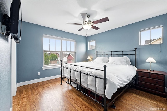 3644 Wabash St, Denver, CO 80238 - bedroom featuring multiple windows, baseboards, wood finished floors, and a ceiling fan