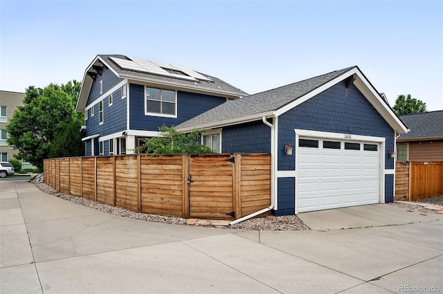 3644 Wabash St, Denver, CO 80238 - view of front of property with a shingled roof, a garage, driveway, and roof mounted solar panels